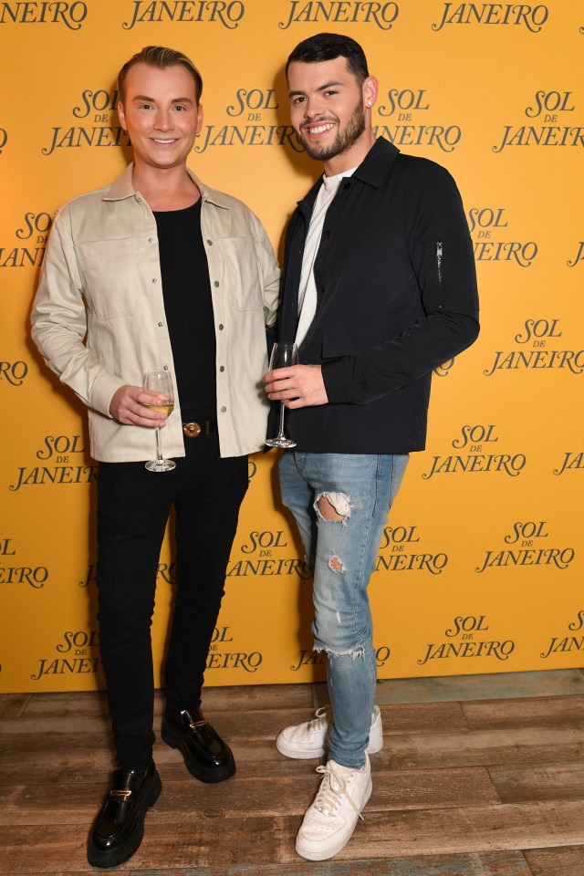 two men standing in front of a yellow wall that says sol de janeiro