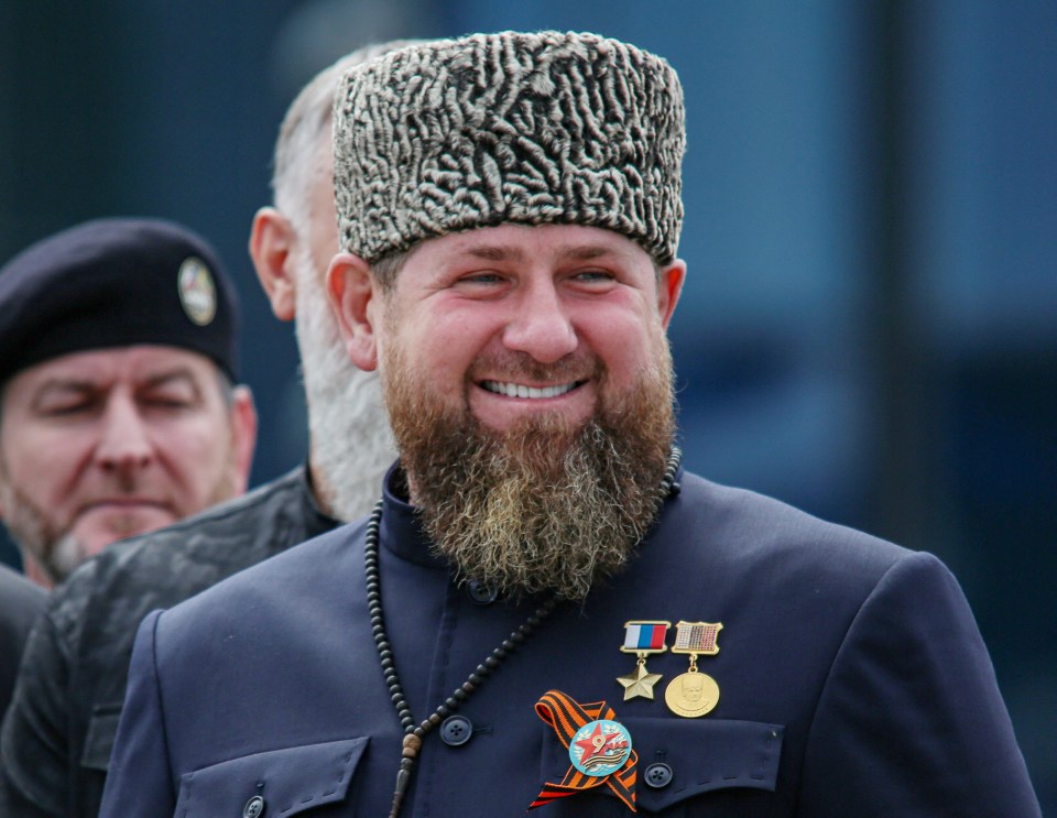 a man with a beard and medals around his neck smiles