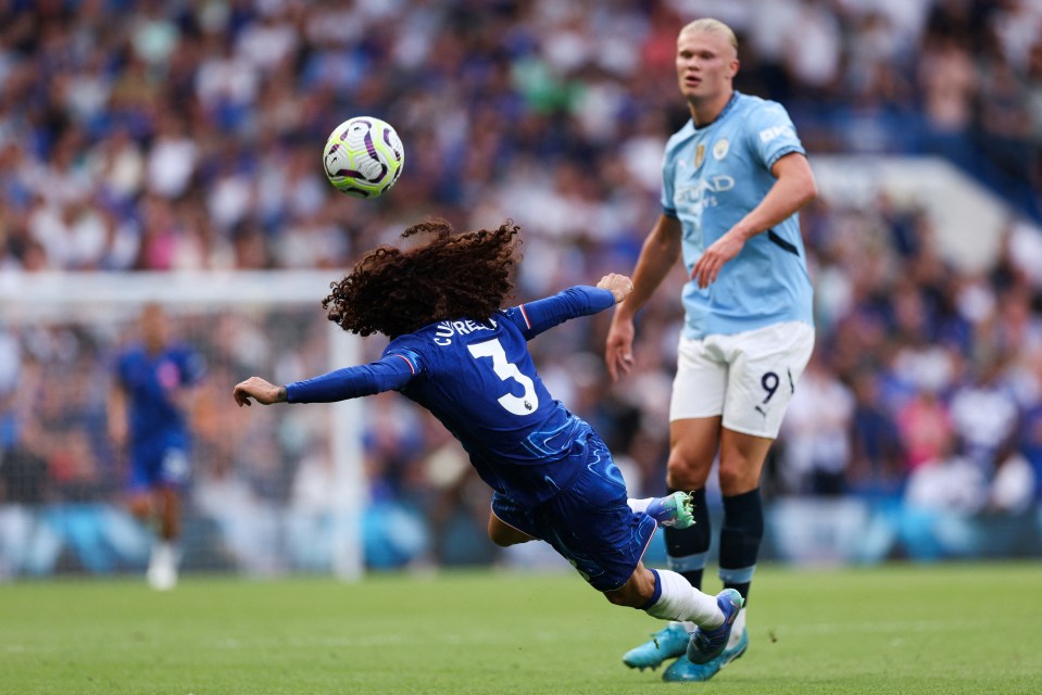 a soccer player with curly hair has the number 3 on his jersey