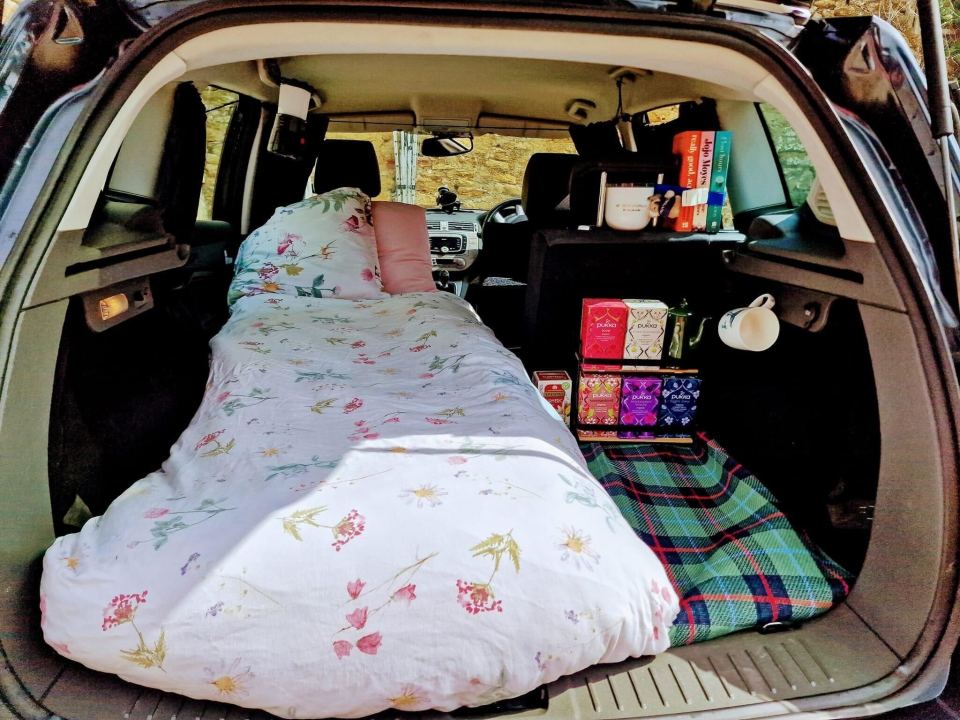 the back of a car with a bed and a book titled ' a dictionary of tea '