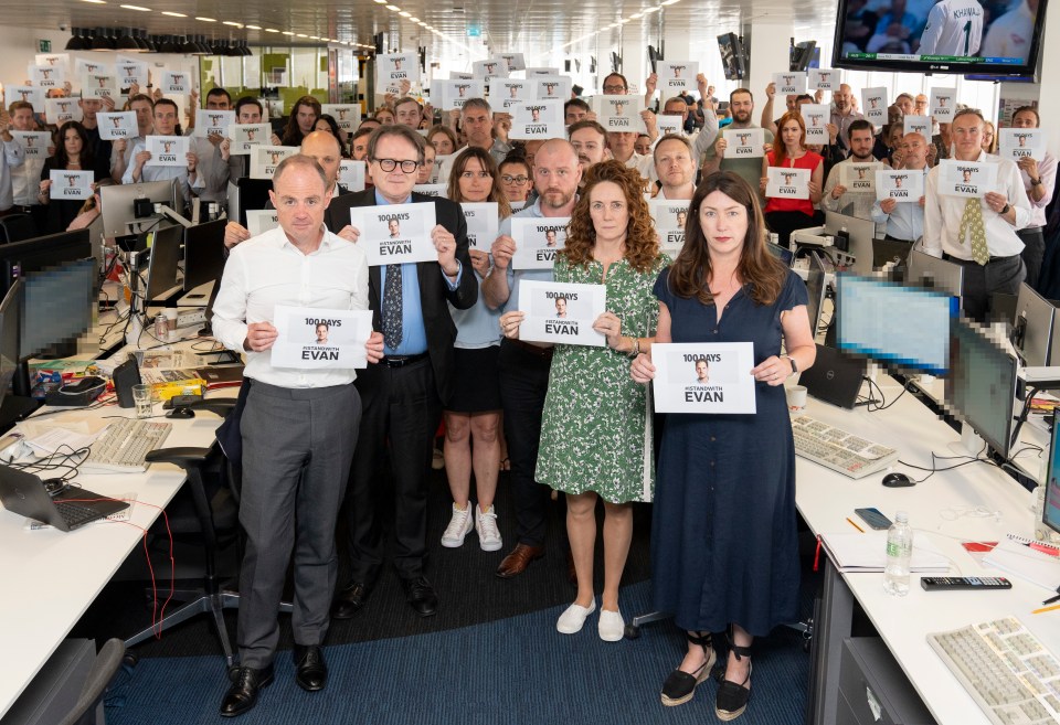 The Sun team hold signs showing support for Evan on July 7, 2023