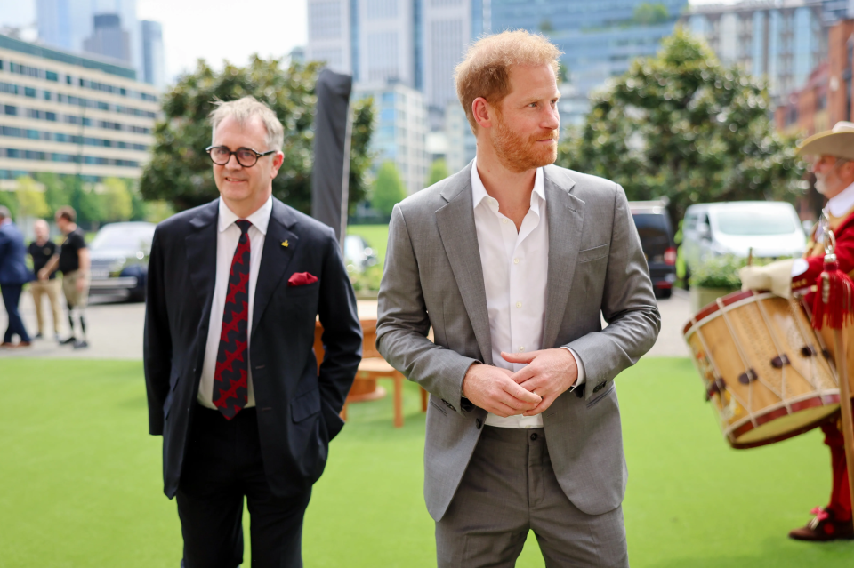 a man in a suit stands next to another man in a suit