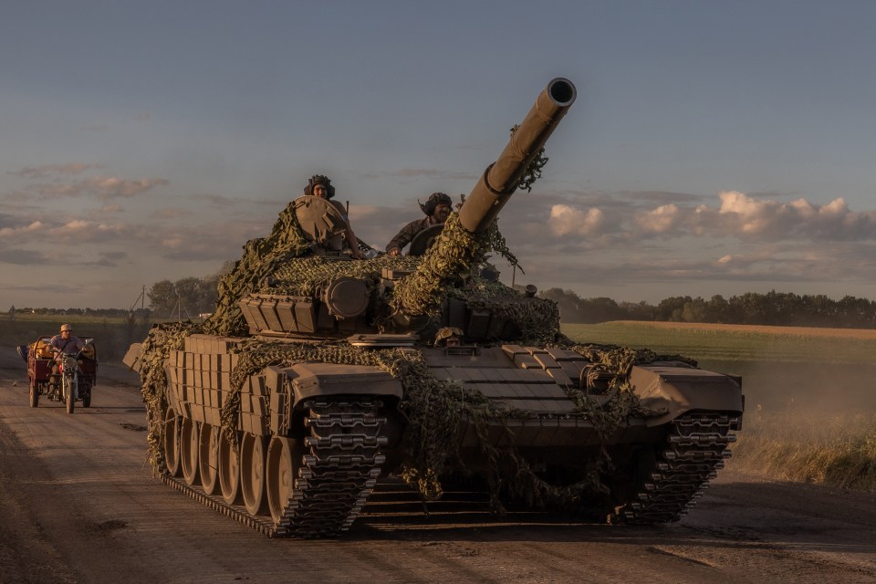 Ukrainian troops ride a Soviet-made tank in the Sumy region