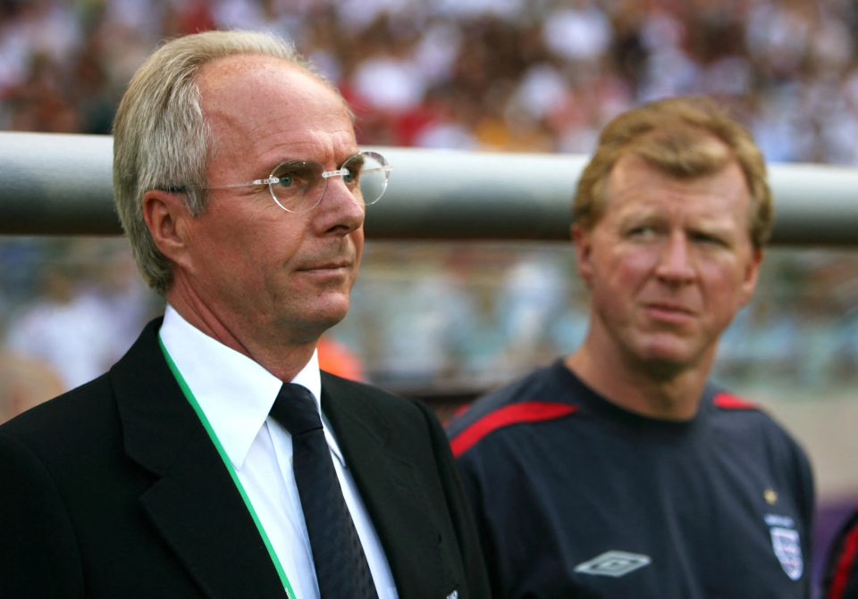 a man wearing glasses stands next to another man wearing an umbro shirt