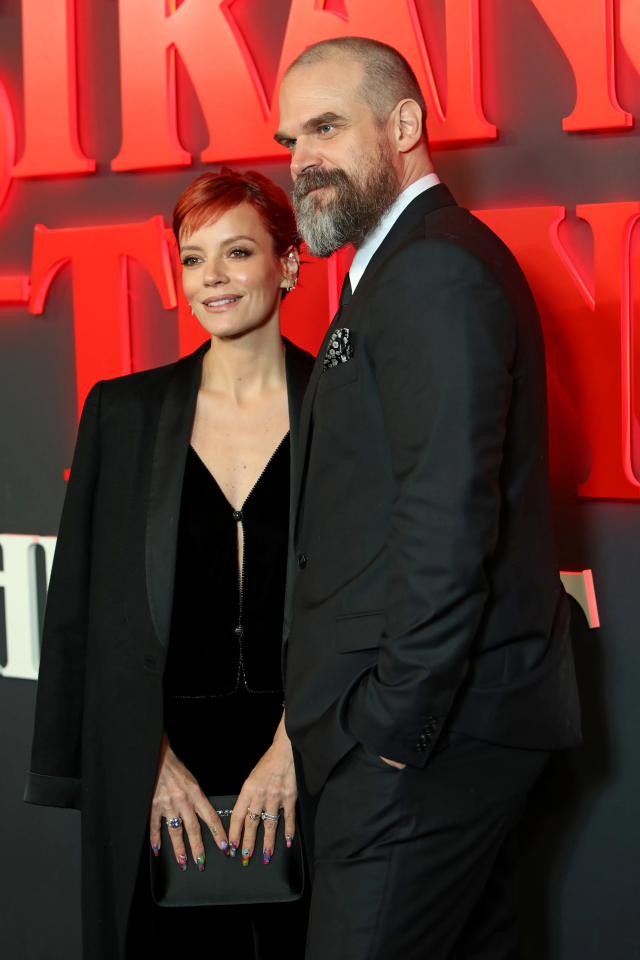 a man with a beard and a woman with red hair pose for a photo