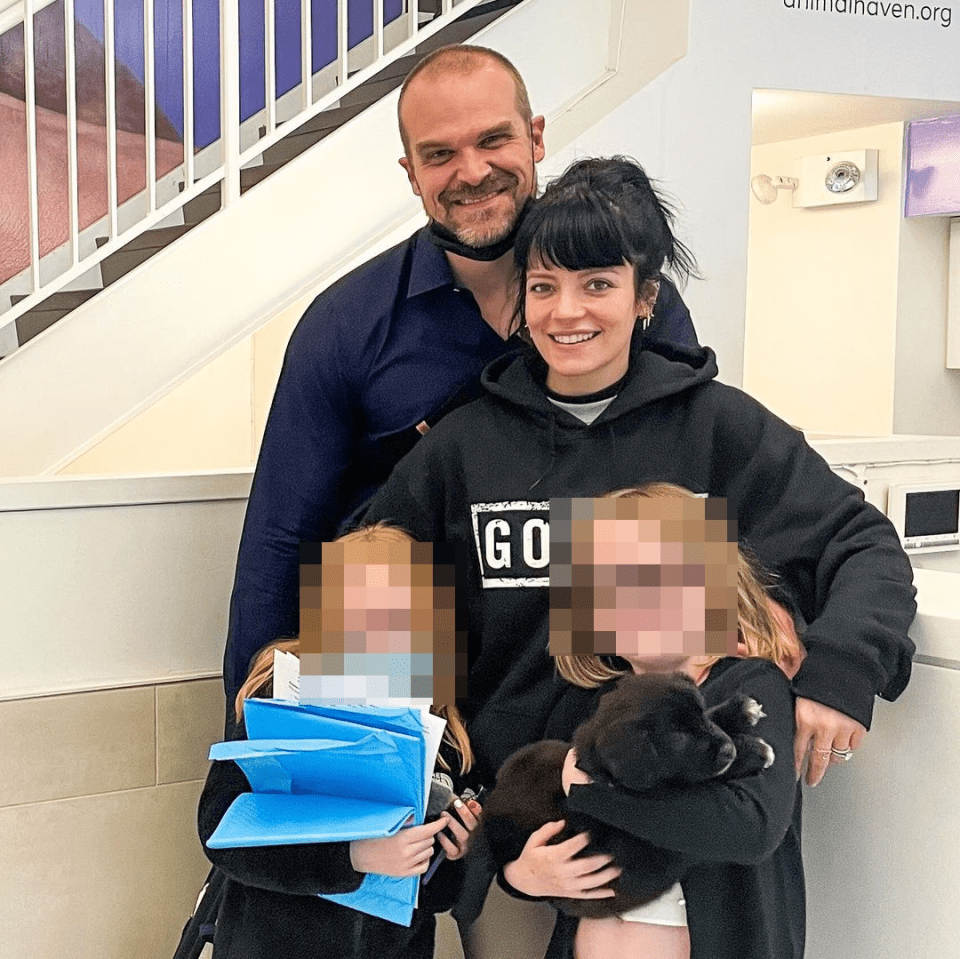 a woman wearing a black go sweatshirt holds a puppy