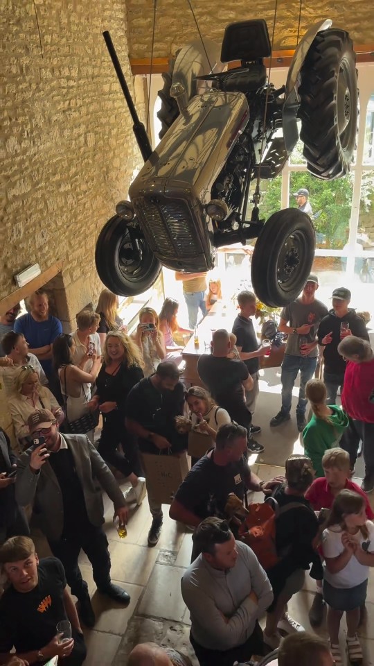 Punters sip pints beneath the flying tractor inside the pub