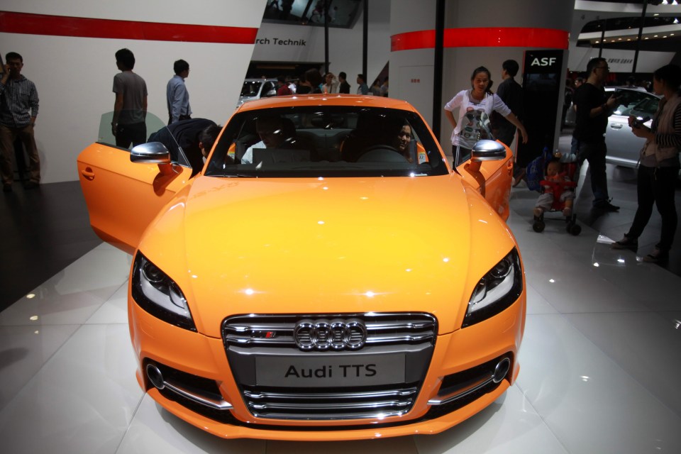 an orange audi tts is on display at a car show