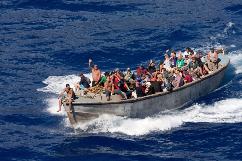 a boat full of people is floating in the ocean