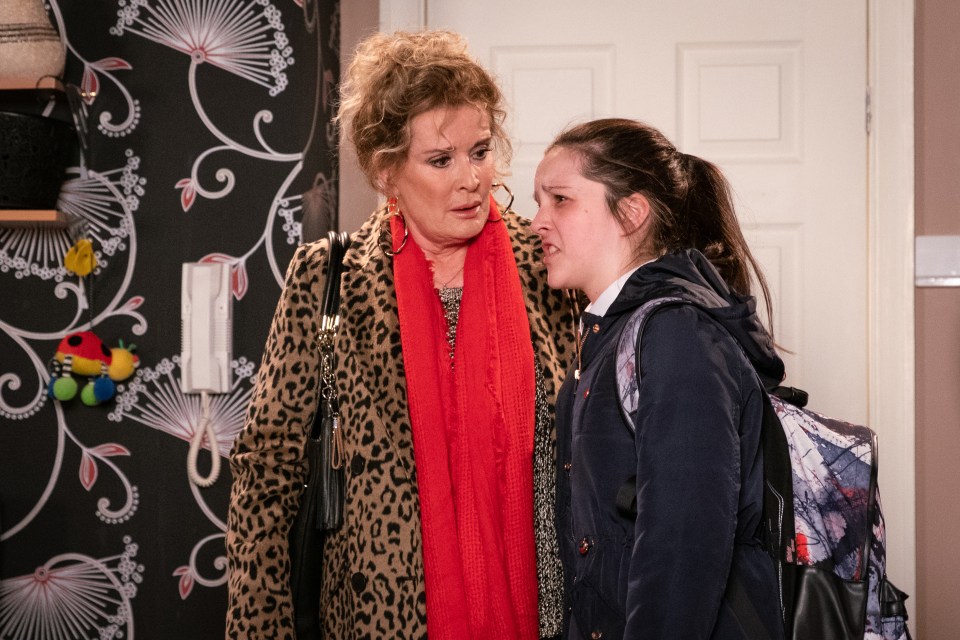 a woman in a leopard print coat talks to a girl with a backpack