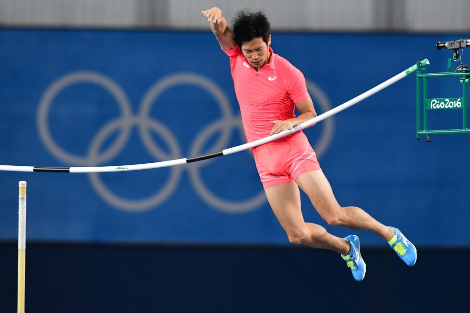 a man is jumping over a pole in front of a sign that says rio 2016