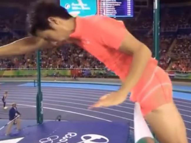 a man is jumping over a hurdle on a track .