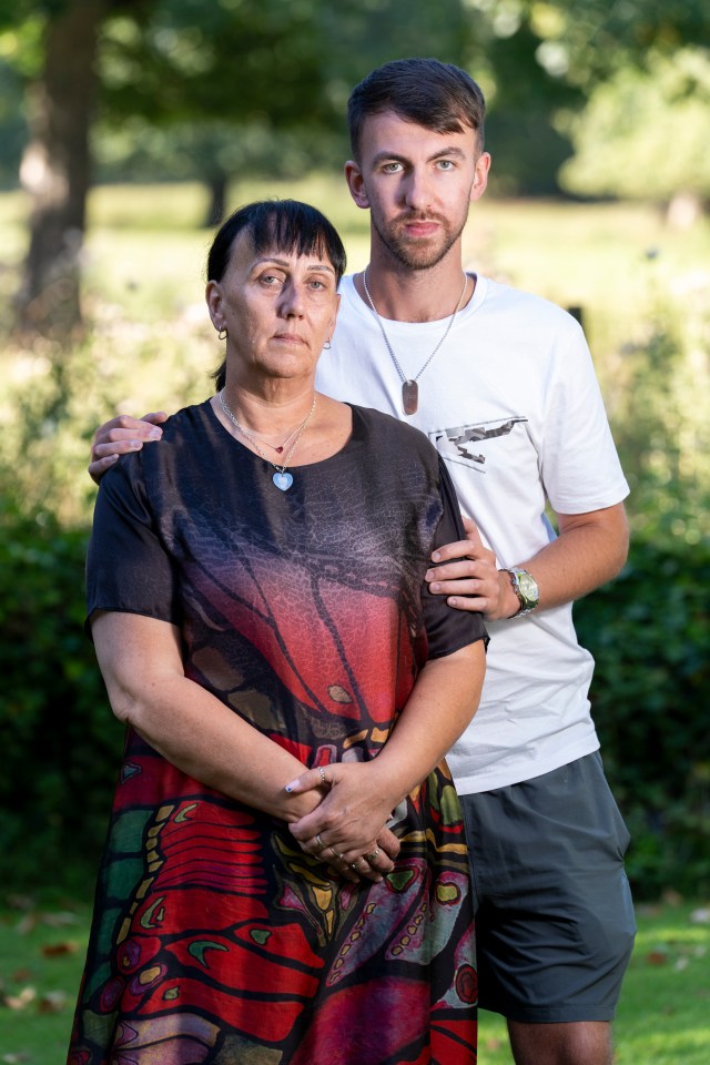 a man and a woman are posing for a picture in a park