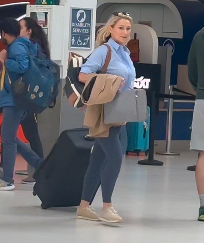 a woman carrying a suitcase in front of a sign that says disability services