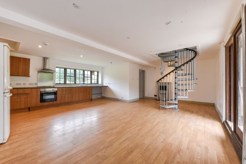 Katie’s huge living room with a spiral staircase has been cleared out