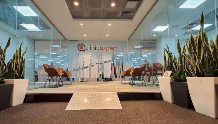 a lobby with chairs and potted plants and a sign that says clinicexpert .