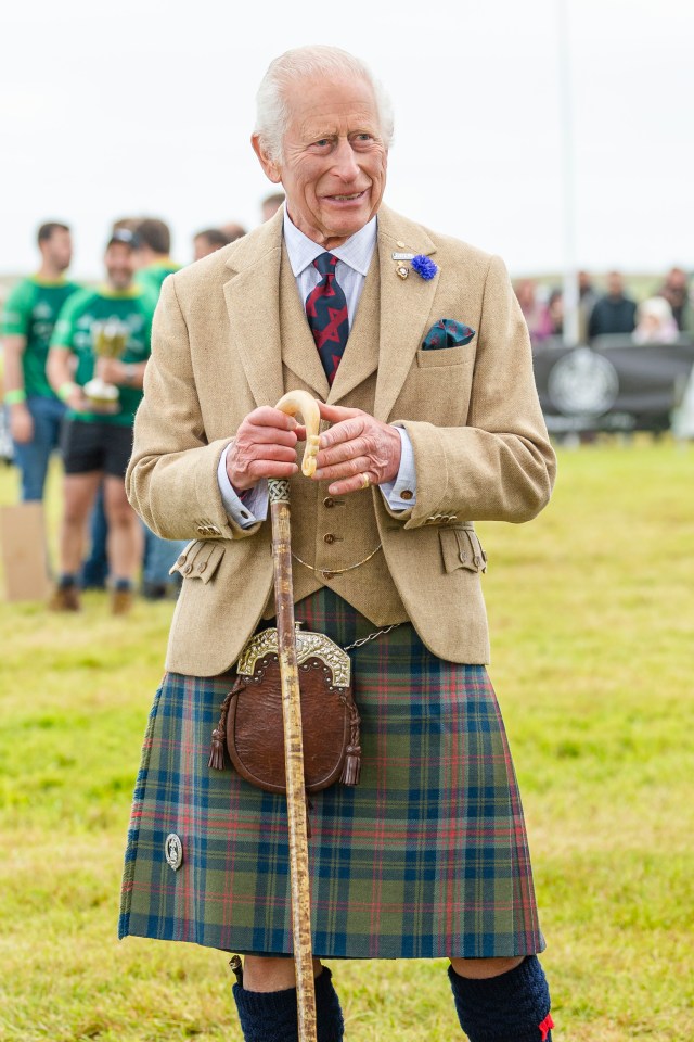 a man in a kilt is holding a cane