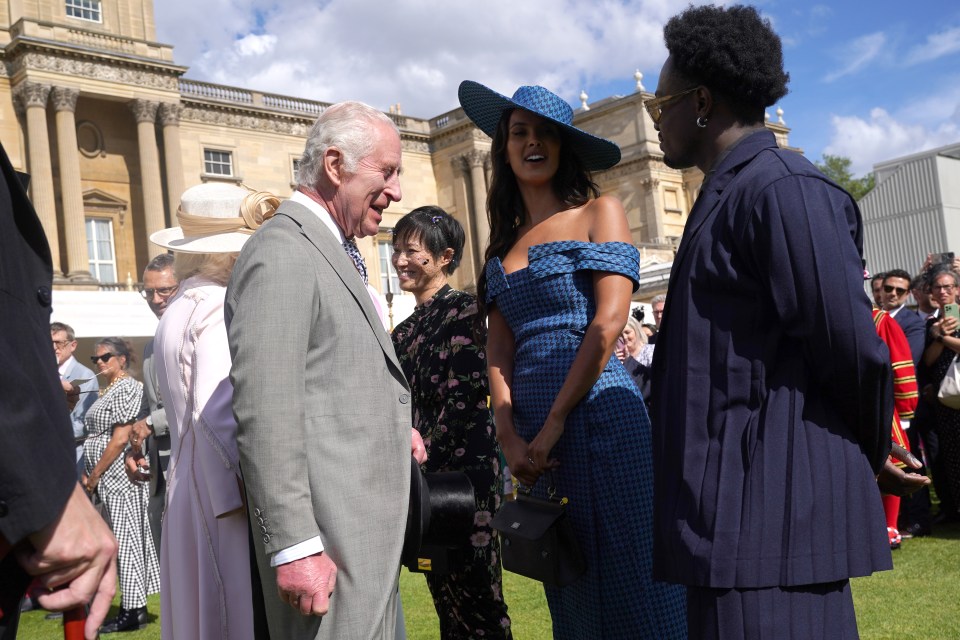 a man in a suit talks to a woman in a blue dress