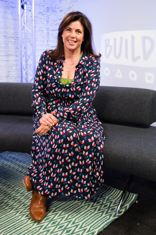 a woman sits on a couch in front of a sign that says build