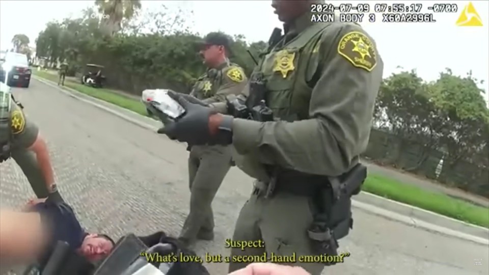 a police officer is talking to a man who is laying on the ground