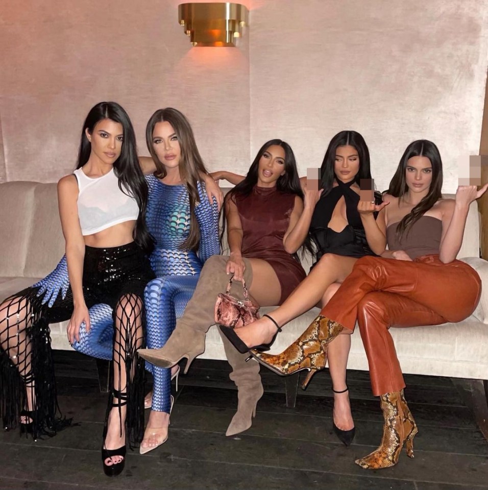 a group of women sitting on a couch posing for a picture