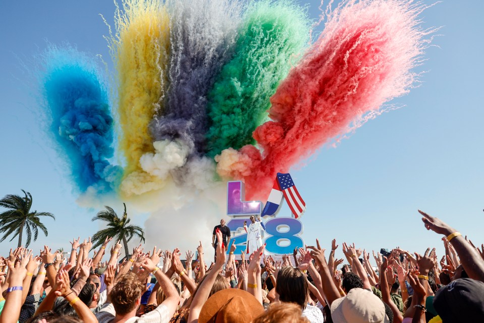 a crowd of people at a festival with smoke coming out of the letters l and 8