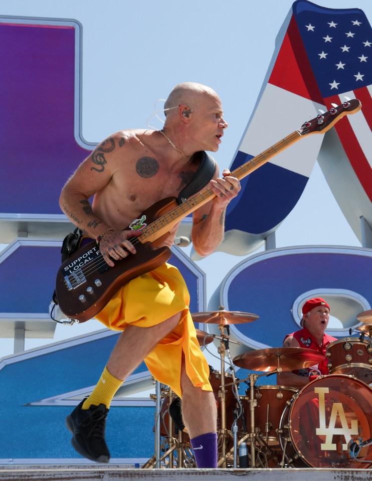 a man playing a guitar with a la logo on the drum set