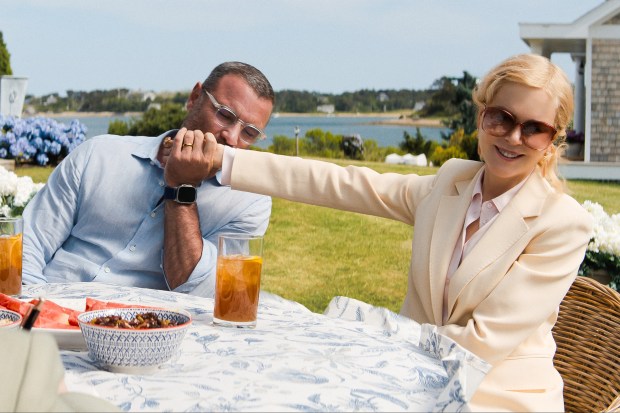 a woman holds a man 's hand while sitting at a table