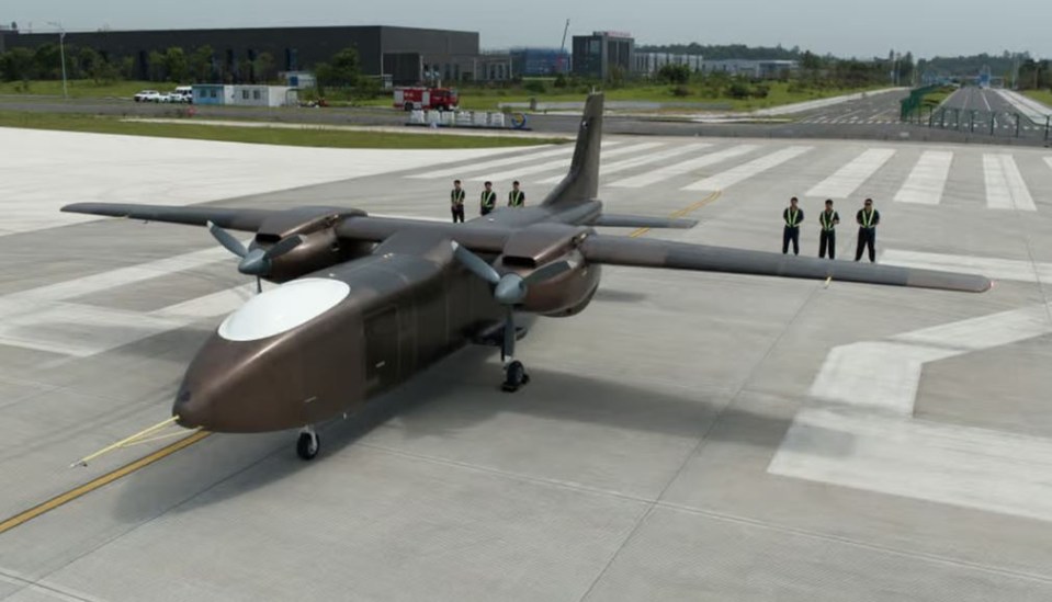 a plane is parked on a runway with a group of men standing behind it