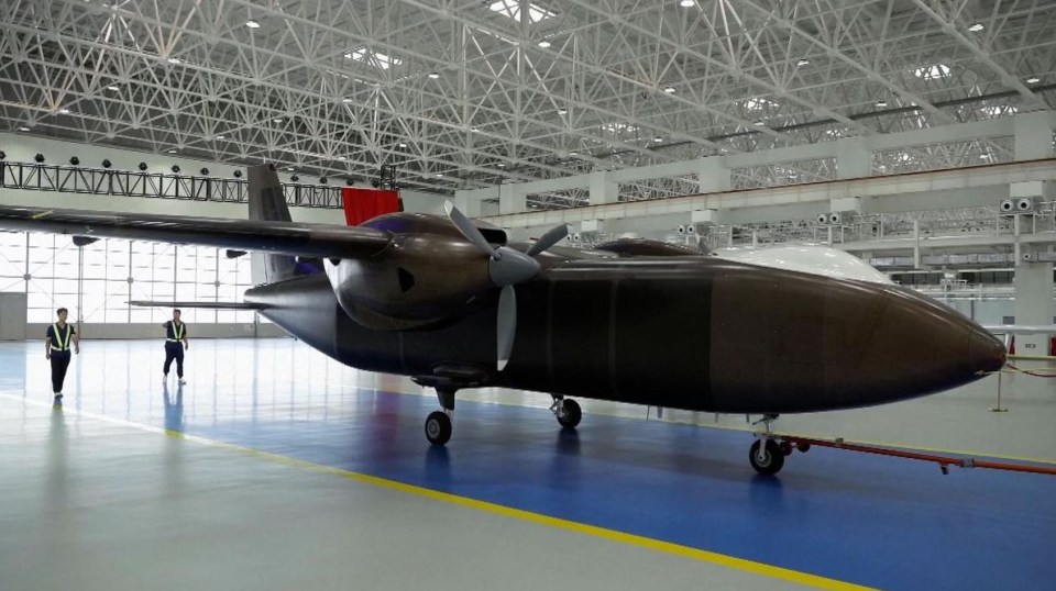 a large airplane in a hangar with a red flag hanging from the ceiling