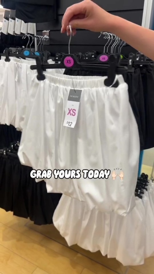 a person is holding up a white xs crop top