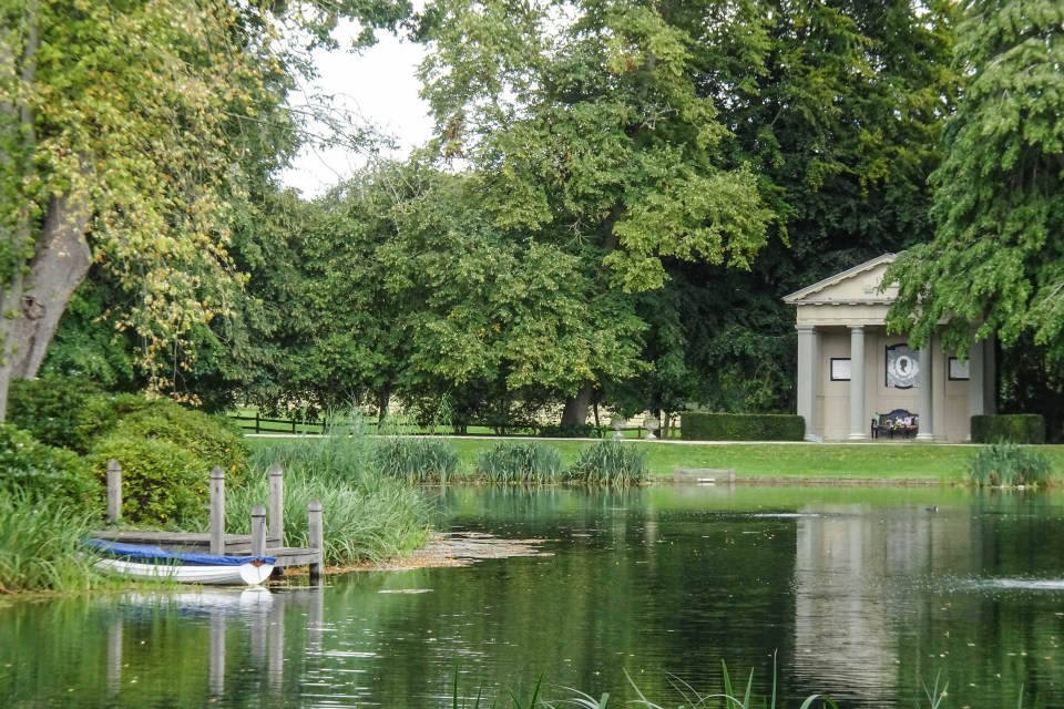 a small boat sits on a dock next to a pond