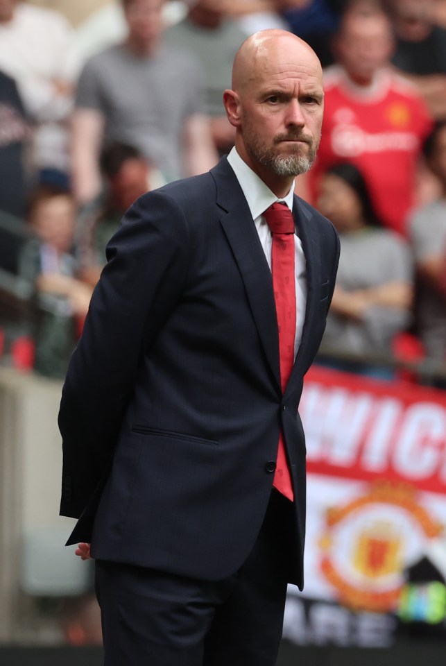 a man in a suit and tie stands in front of a sign that says wig