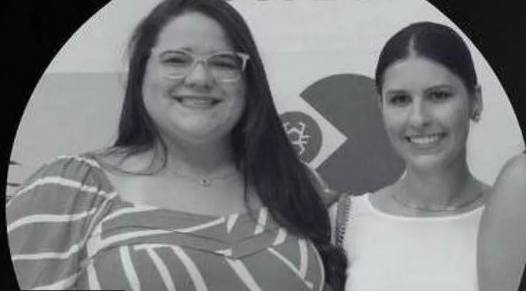 two women are posing for a picture together in a black and white photo .