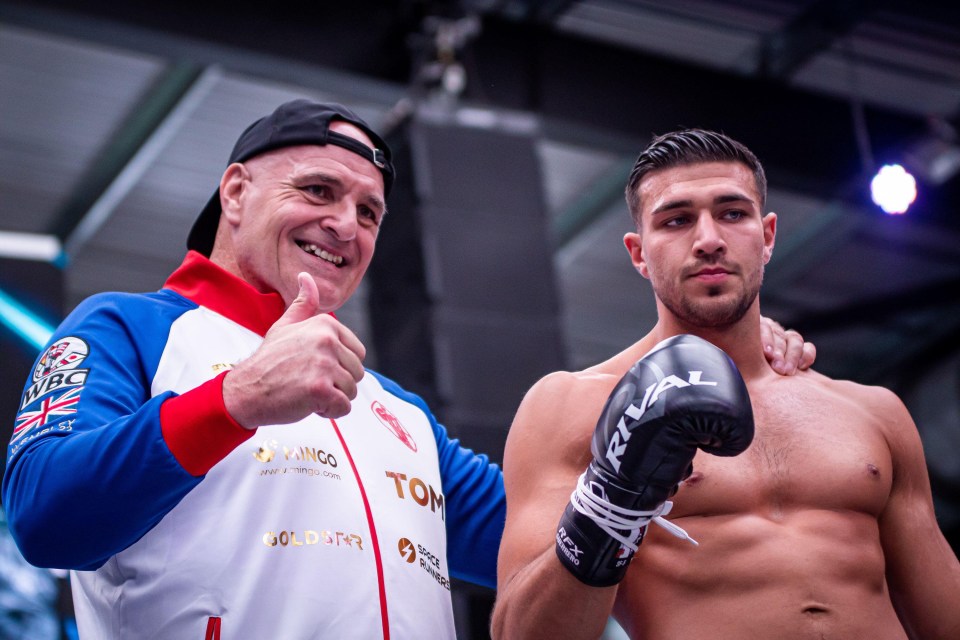 a man giving a thumbs up next to a man wearing rival boxing gloves