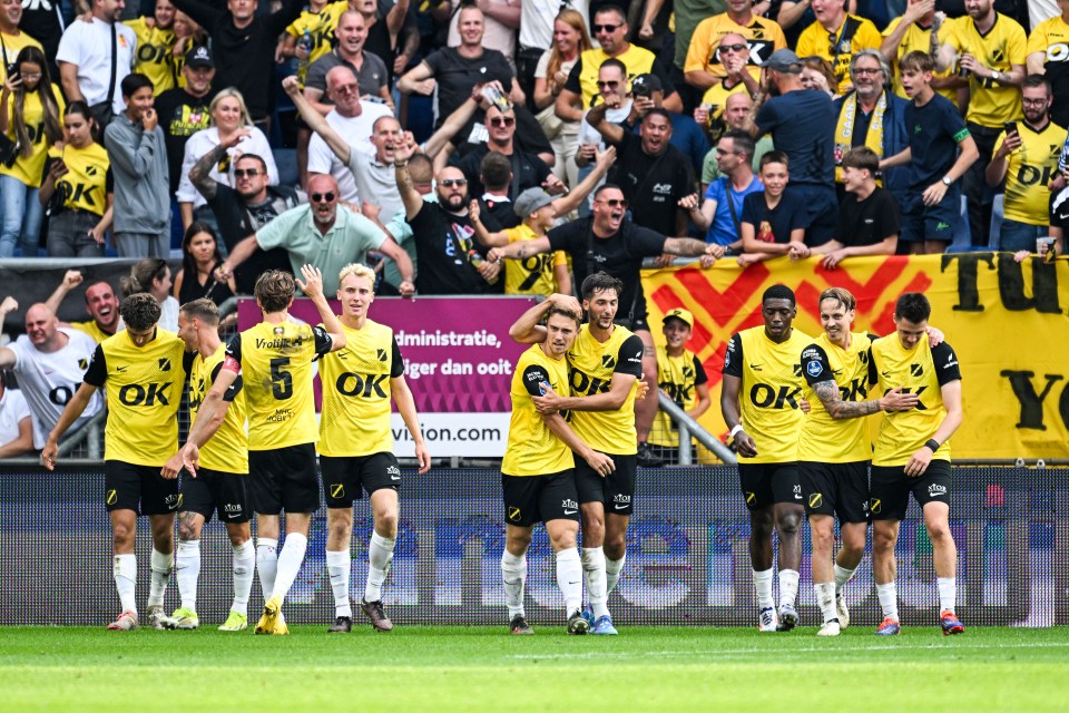 a group of soccer players wearing yellow jerseys with ok on them