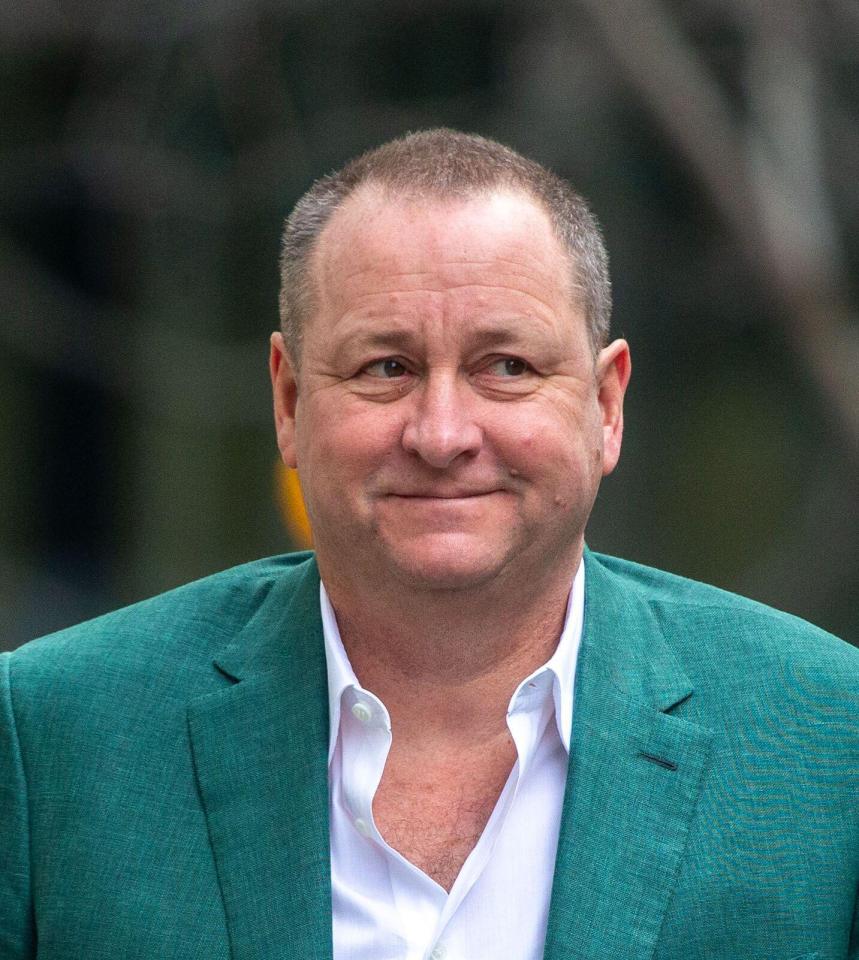 a man wearing a green jacket and white shirt smiles for the camera