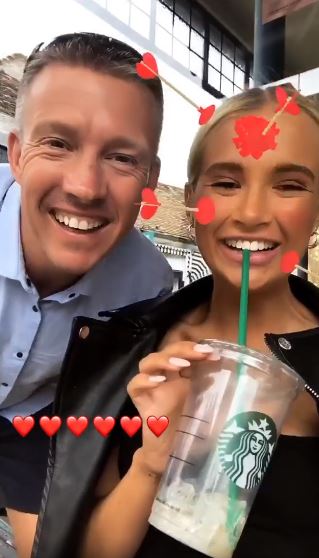 a man and a woman are drinking a starbucks drink together .