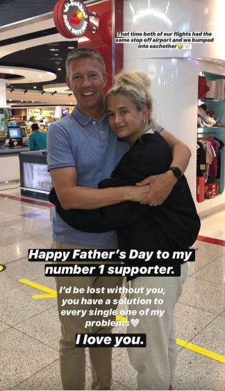 a man and a woman are hugging each other in an airport .