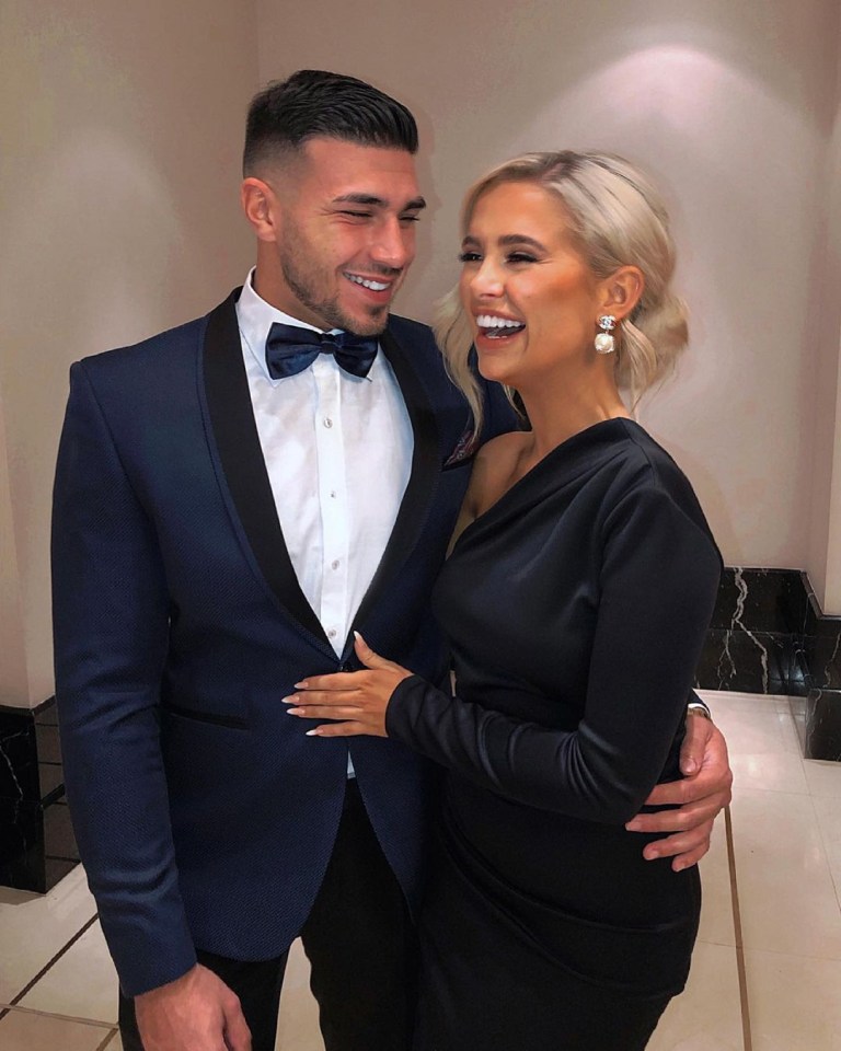 a man in a tuxedo stands next to a woman in a black dress