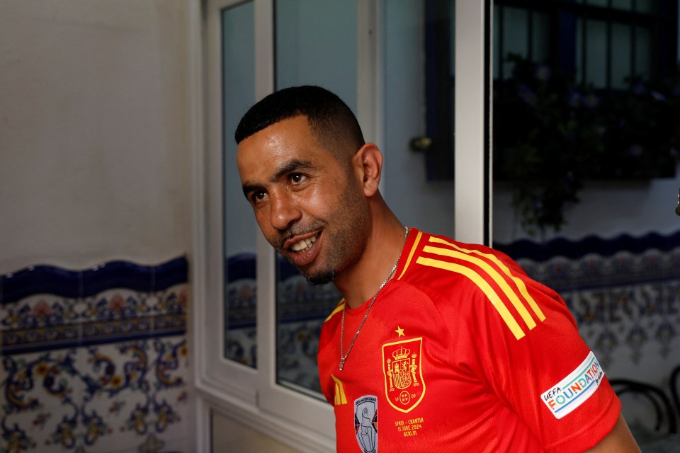 a man wearing a red shirt that says ' espana ' on it