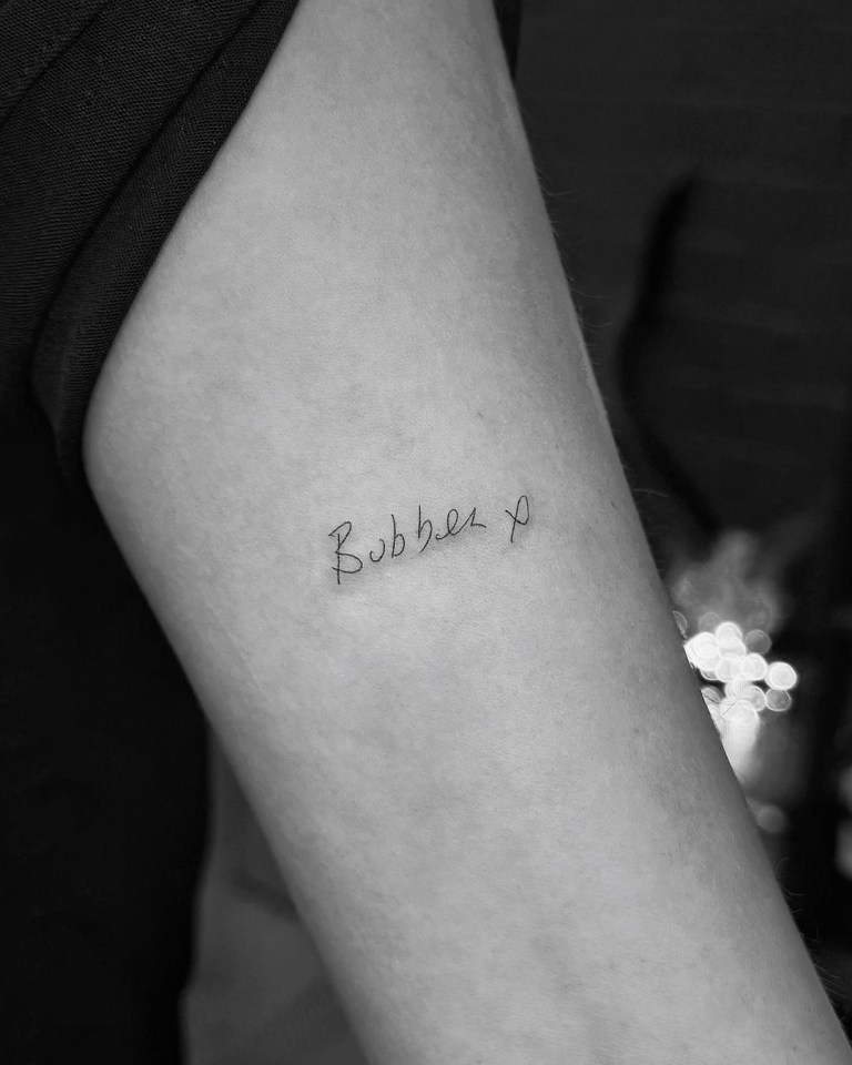 a small tattoo on a person 's arm says bobbie x