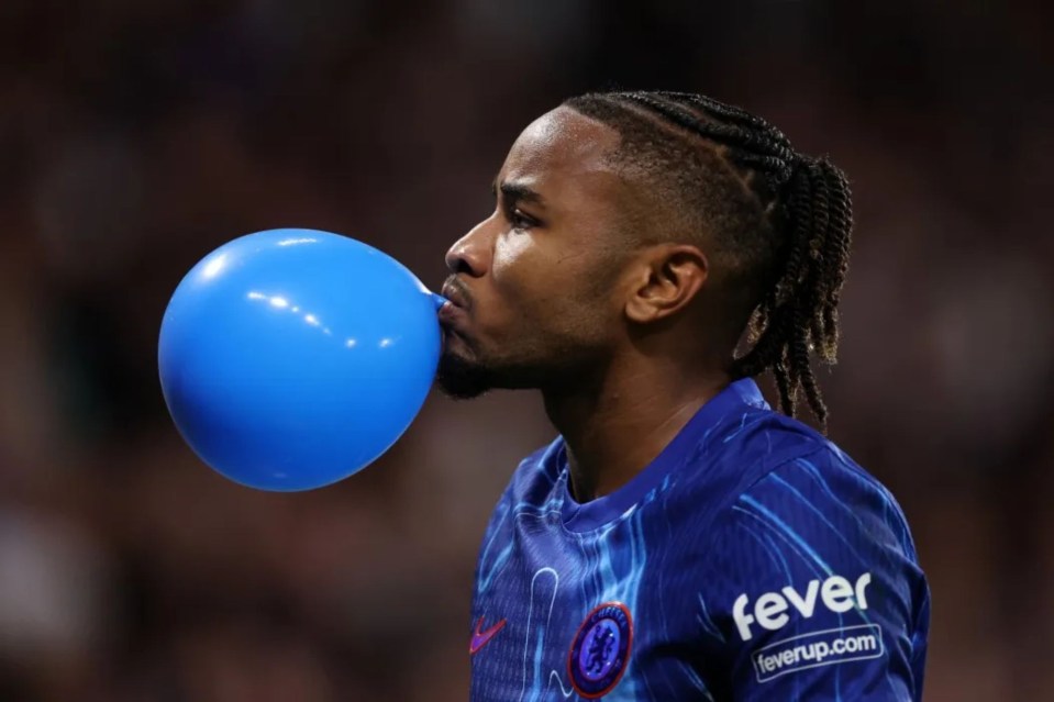 a man blowing up a blue balloon with the word fever on his sleeve