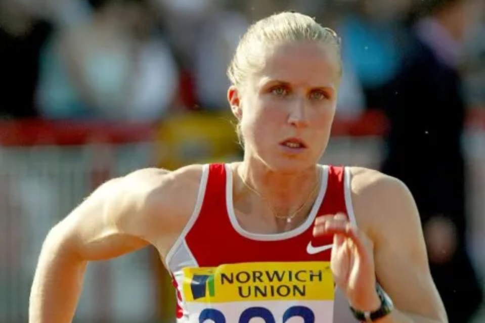 a female runner wearing a red and white nike tank top is running in a race sponsored by norwich union .