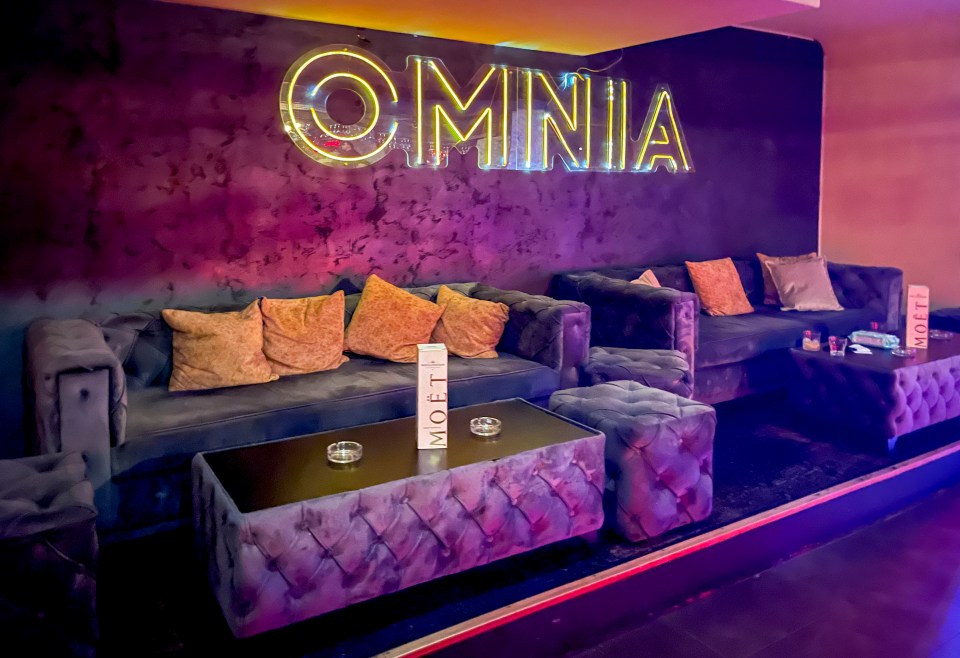 a room with a neon sign that says omnia