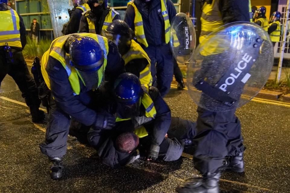 A protester was pulled to the ground by cops as the night of violence continued