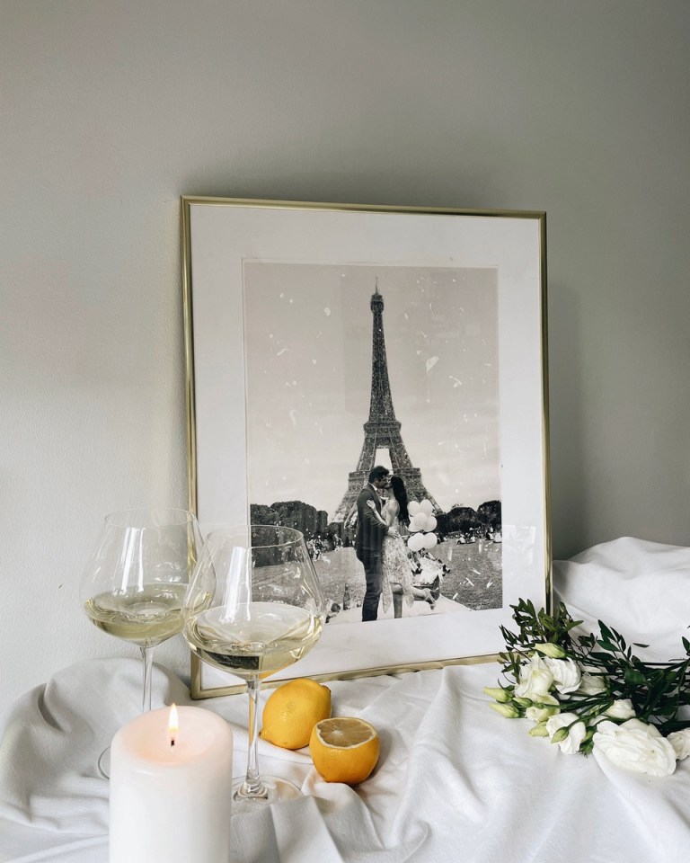 a framed picture of a couple kissing in front of the eiffel tower