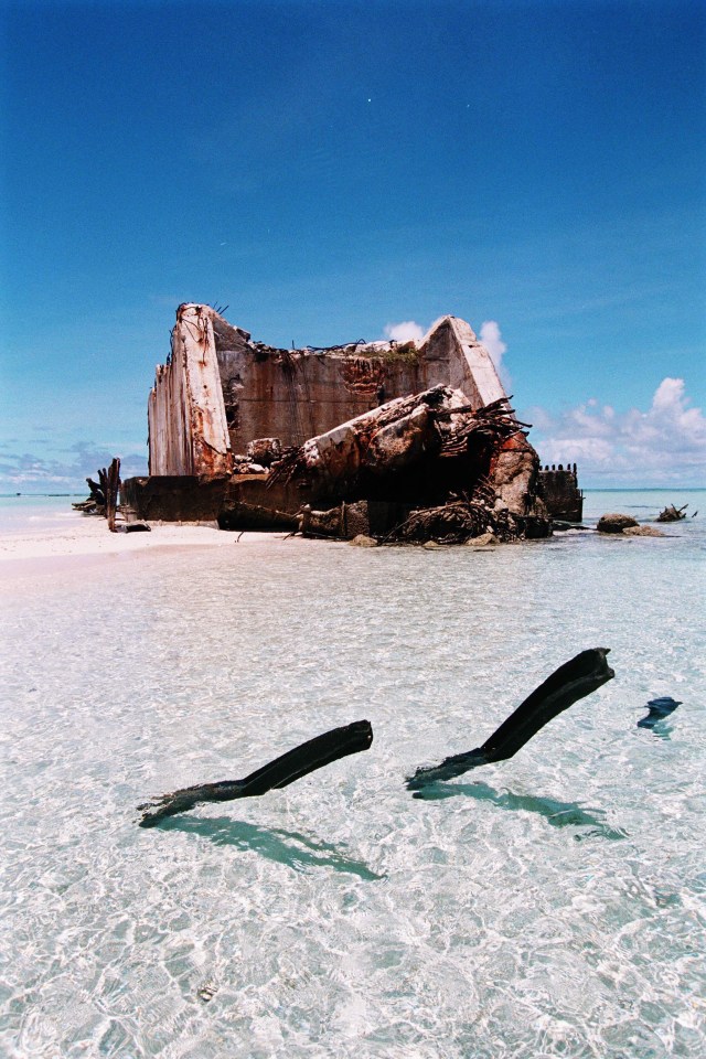 a shipwreck sits in the middle of the ocean