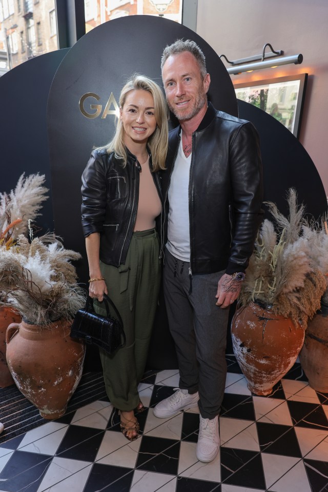 a man and woman pose in front of a sign that says ga