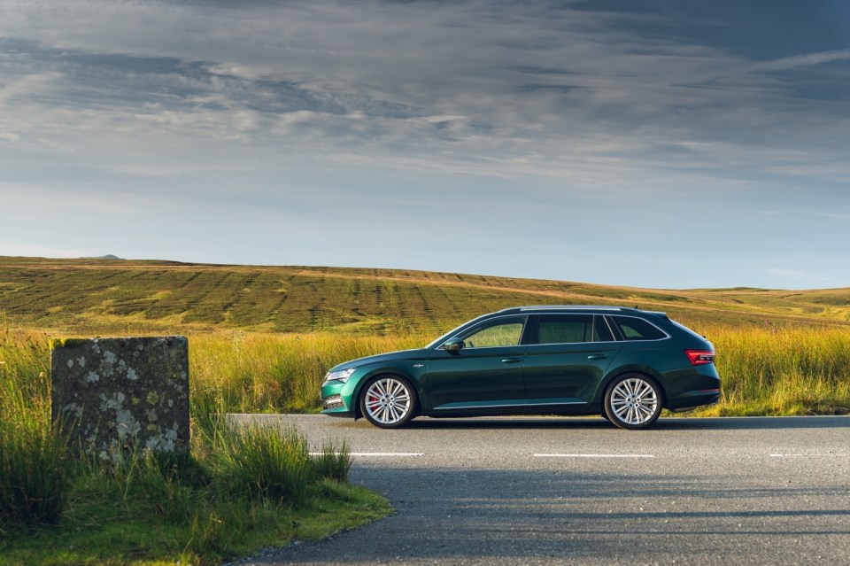 a green car is parked on the side of the road